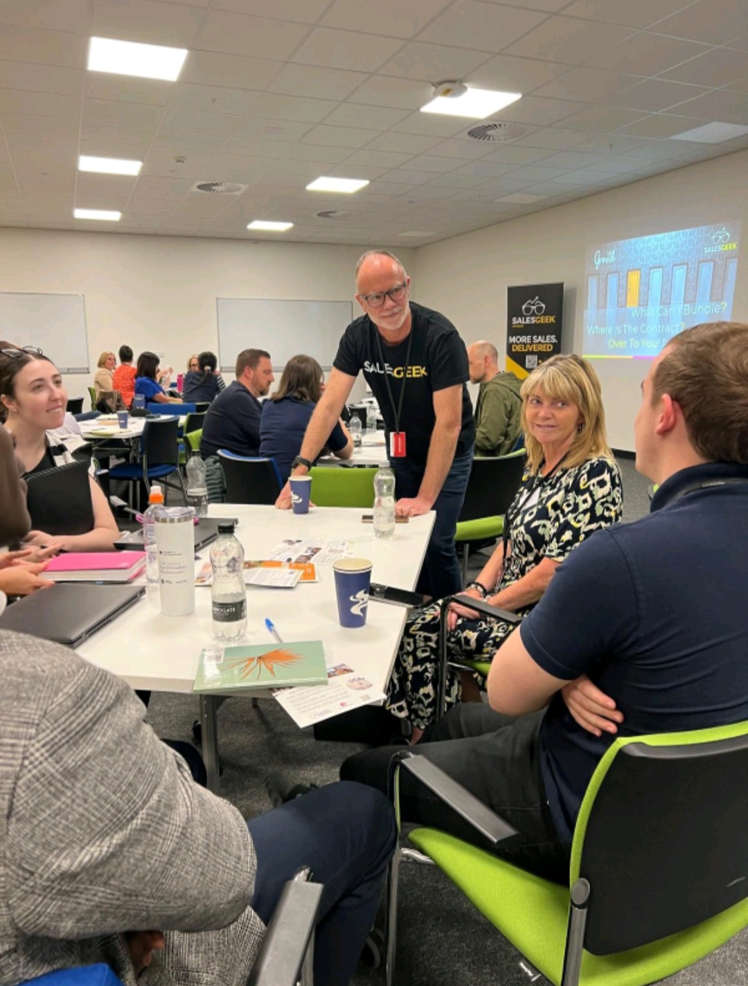 A Sales Geek franchise owner in conversation with clients around a table